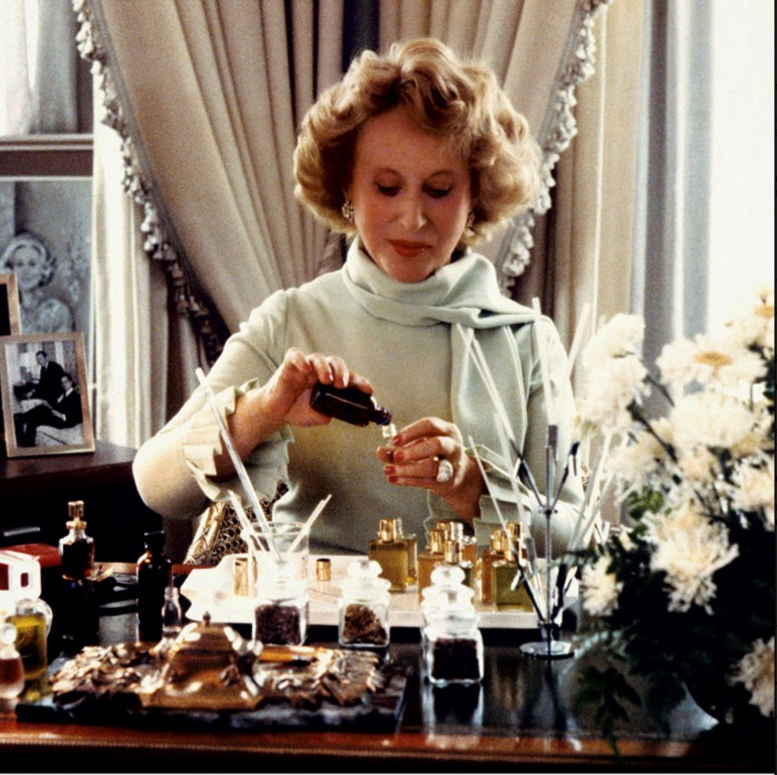 Estee Lauder mixing fragrance oils at her desk