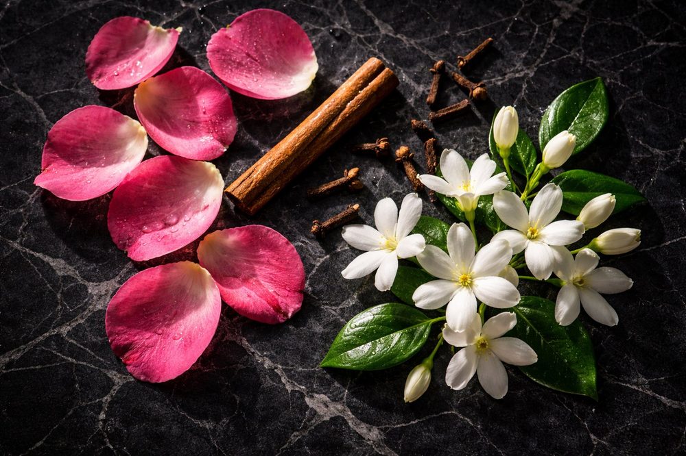 Rose petals, jasmine flowers and cinnamon representing heart notes in perfumery