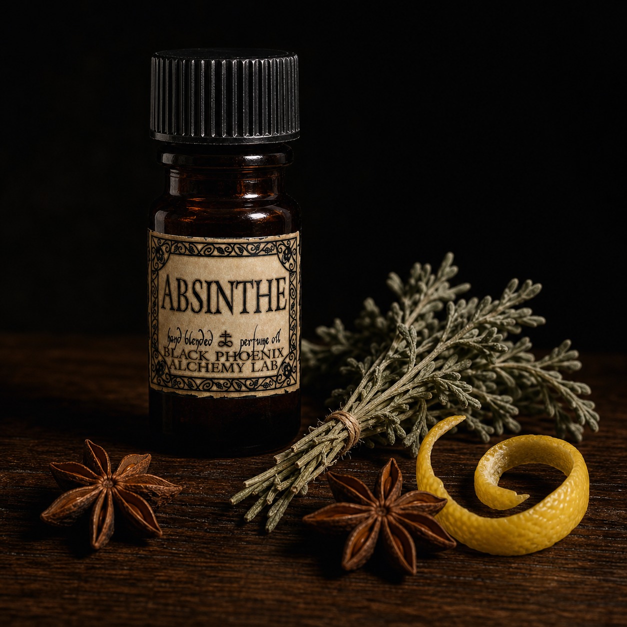 Black Phoenix Alchemy Lab Absinthe perfume oil bottle beside dried wormwood, star anise, and lemon peel