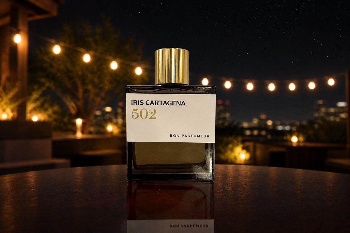 Bon Parfumeur Iris Cartagena bottle on an outdoor table at night, string lights and a starry sky blurred behind it